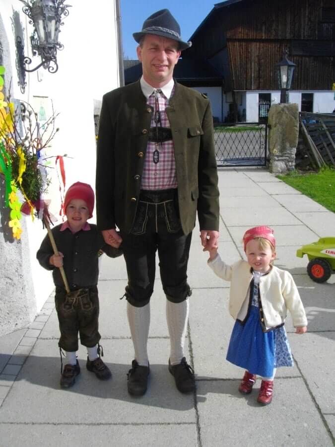 Familienvater mit zwei Kindern in Tracht vor Bauernhof, Urlaub Schloss Saalhof, Zell am See
