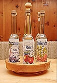 Drei Flaschen hofeigener Schnaps vom Schloss Saalhof im Holzständer auf Holztisch